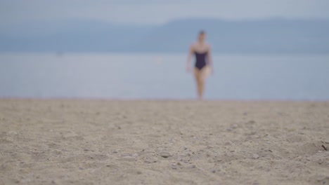 Vista-Lejana-De-Una-Chica-Atractiva-Caminando-Desde-El-Agua