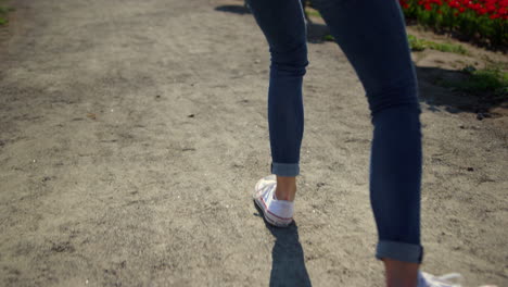 closeup woman legs walking in sport shoes. unknown girl going in white sneakers.