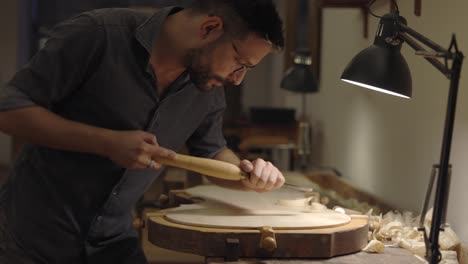 Luthier-creating-violin-in-workshop