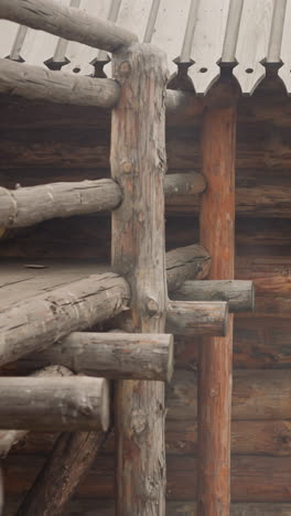 medieval log building and high wooden fence with stairs and platform for viewing territory outside yard. ancient house from middle ages period