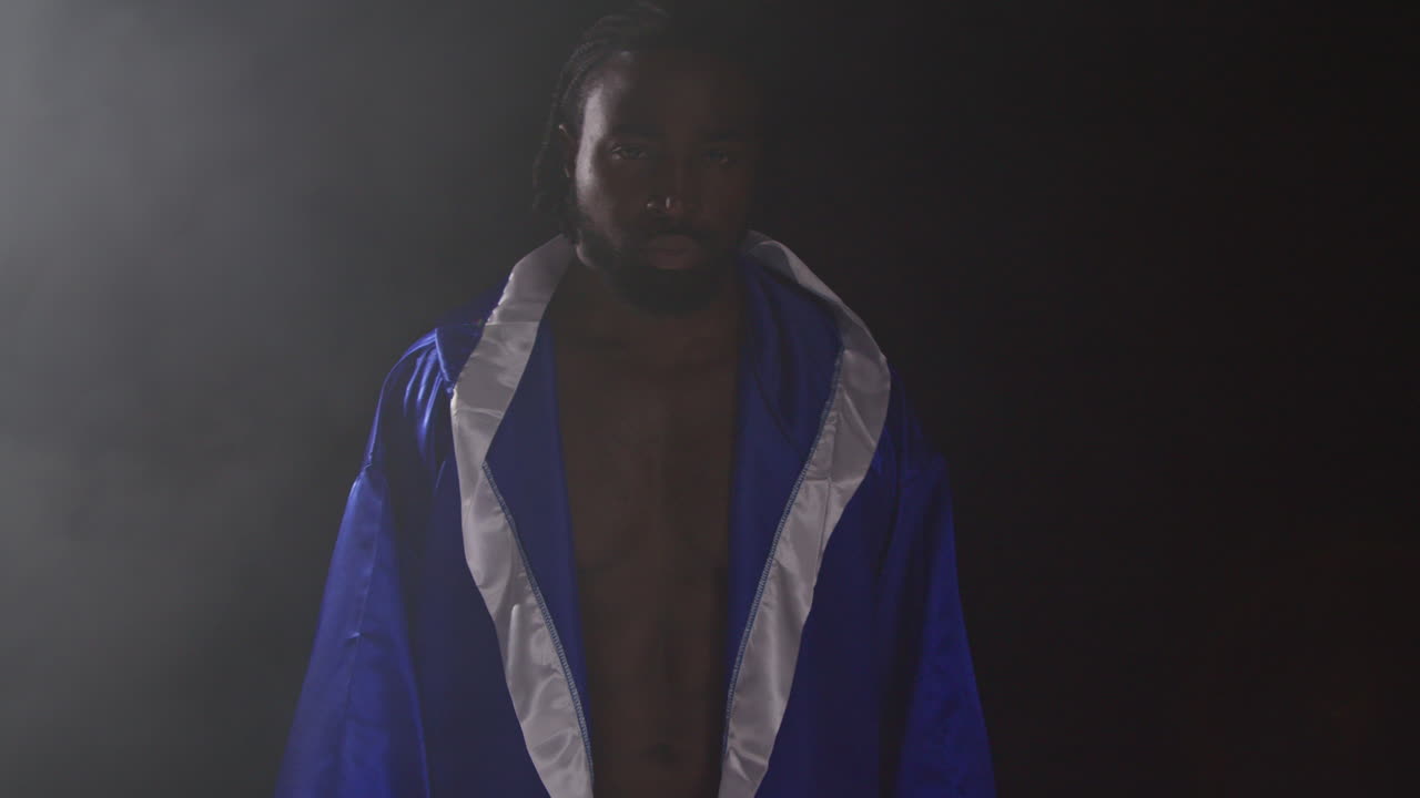retrato de un boxeador con guantes y túnica en el ring antes del comienzo de un partido de boxeo saludando y saludando a los aficionados 1
