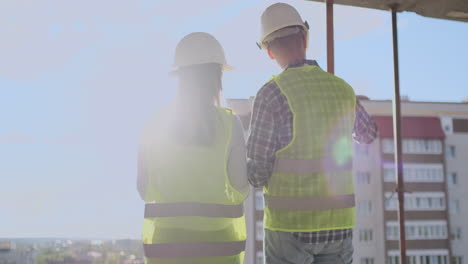 building workers working at construction site builders looking in blueprint back view copy space. building development teamwork and people concept.