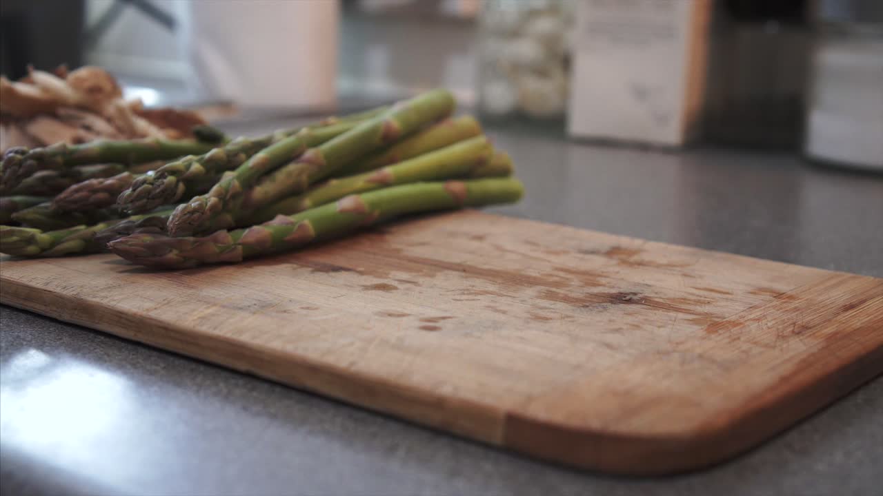 Chef cleaning and Chopping raw Asparagus