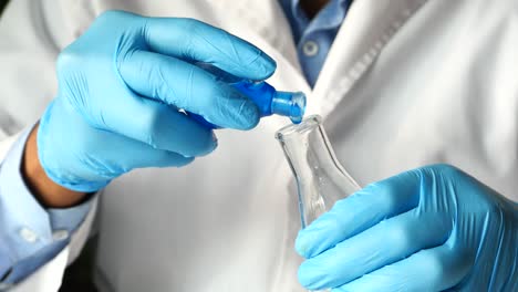 scientist pouring liquid into a flask