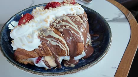 gourmet croissant with chocolate, strawberries, and whipped cream