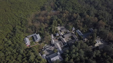 Aerial:-Wu-Wei-Si-Kung-Fu-School-Temple,-nestled-in-dense-China-forest