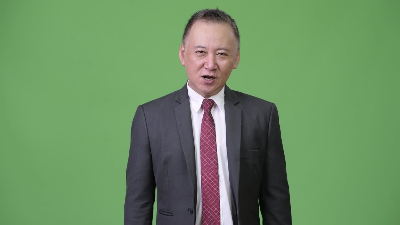 성숙한 일본인 사업가들이 엄지손가락을 올리고 있습니다.