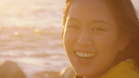 행복한 아시아 여성의 초상화 웃음 휴가를 즐기고 여행 라이프 스타일을 탐험 해변에서 휴식을 취하고 바람이 불고 있는 머리카락으로 일몰에 긍정적 인 느낌