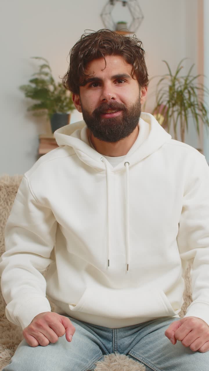 Giovane felice che guarda la TV che celebra il successo che vince alla lotteria che vince la fortuna che si siede sul divano