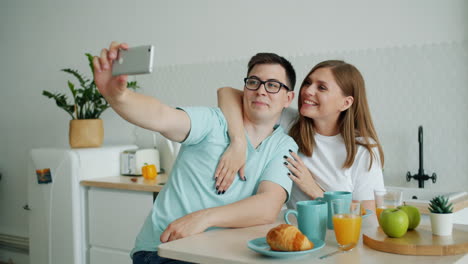 couple taking a selfie during breakfast in the kitchen