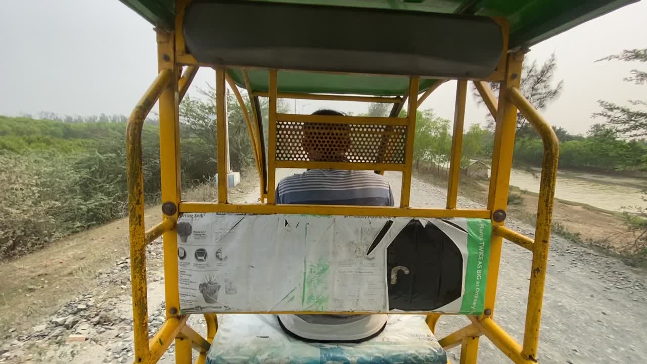 tiro pov de e-rickshaw o rickshaw eléctrico, un hombre conduciendo un e-rickshaw en la carretera del pueblo