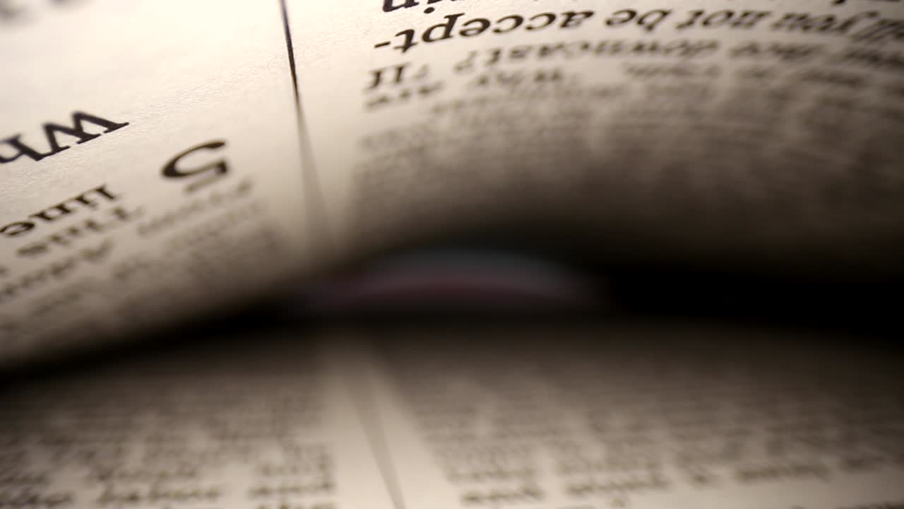 Slowly pushing lens into a book @ words eye diagonal view of the pages