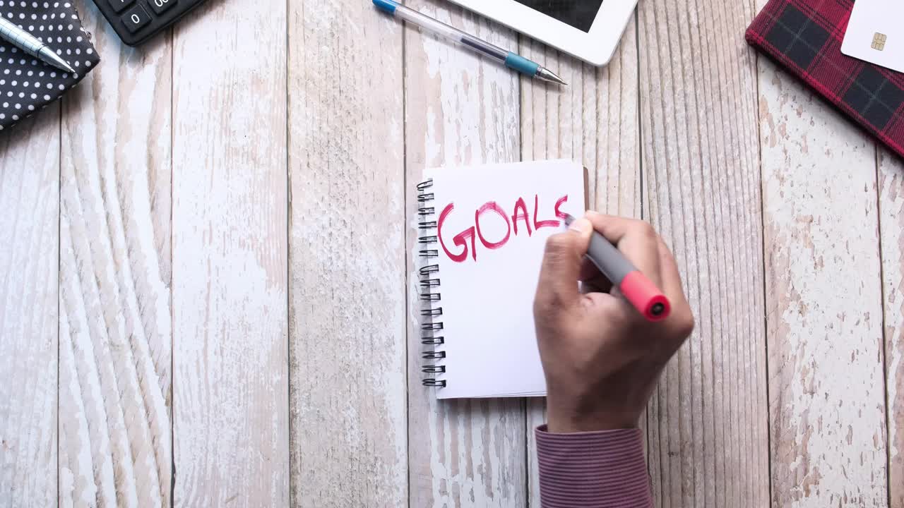 Hand writing goals on a notebook