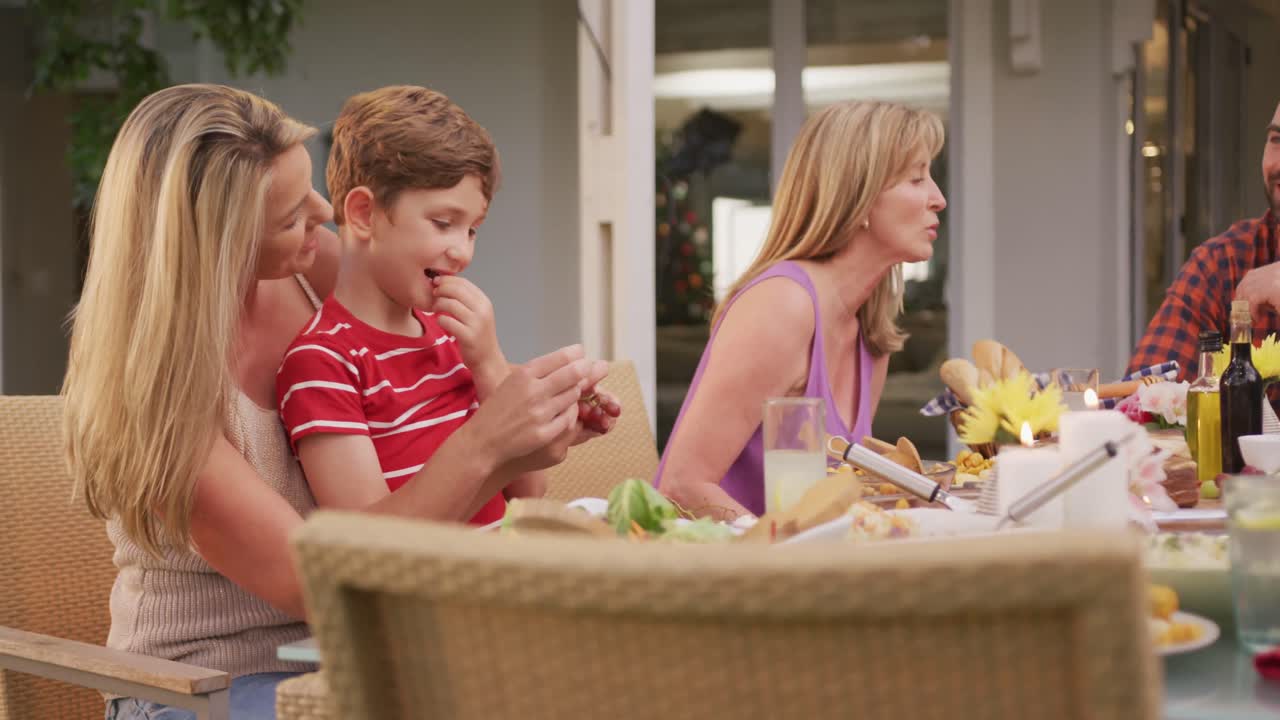 Famiglia di tre generazioni che pranza all'aperto