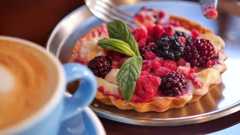 a delicious berry tart served with coffee in a cafe