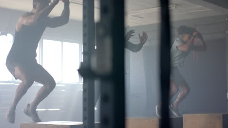 exercising in gym, men performing box jumps and strength training workout