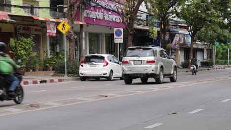 vehicles and motorcycles navigating a city street