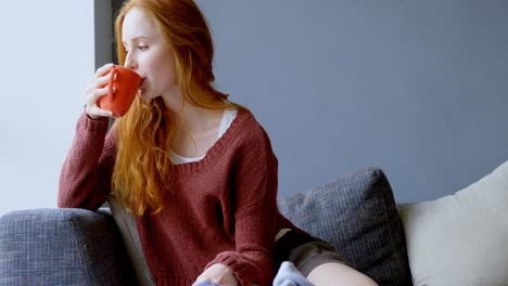 Woman-having-coffee-in-living-room-4k