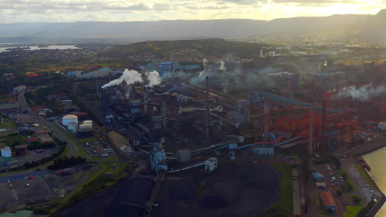 humo saliendo de pilas de humo en una fábrica industrial en la costa de wollongong en australia