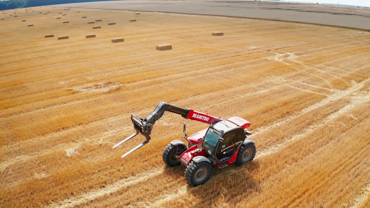 Aerial View of Farmland with Tractors and Bales