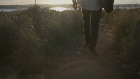 person walking on a trail at sunset