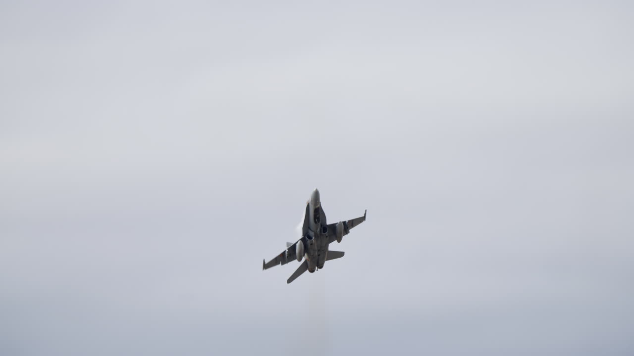 Powerful Fighter Jet Soaring Upwards Against a Cloudy Sky