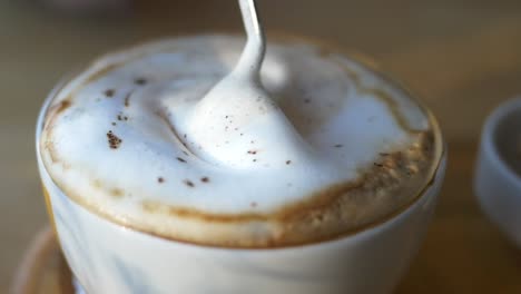 primer plano de un capuchino con cuchara