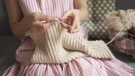 編み針ウールの服を編む女性の手の接写。女性の趣味