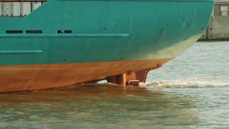 ship propeller creating prop wash underwater of massive container ship