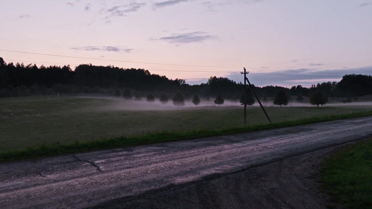 Nebbia serale che copre una strada rurale lituana vicino a una tesa zona di frontiera orientale
