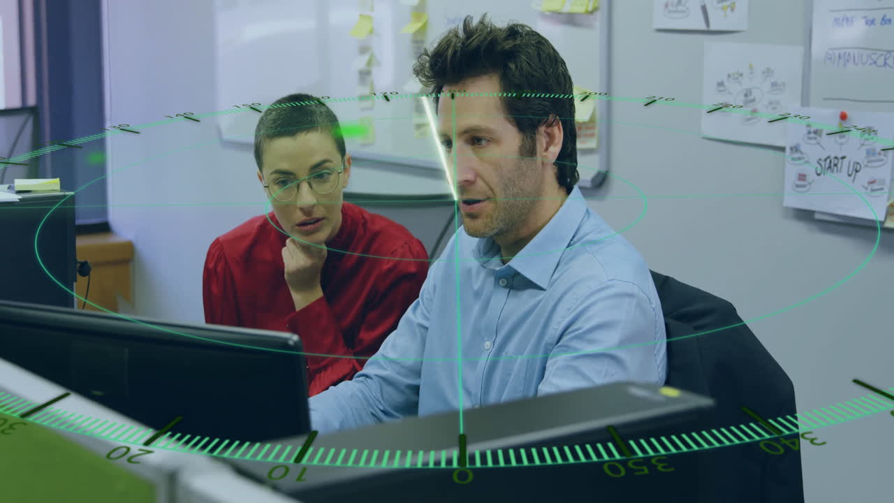 Two colleagues working at computer with digital radar animation overlay