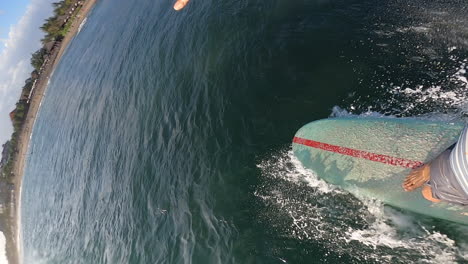 man dangerously avoiding other surfer while cathing a wave, pov vertical view