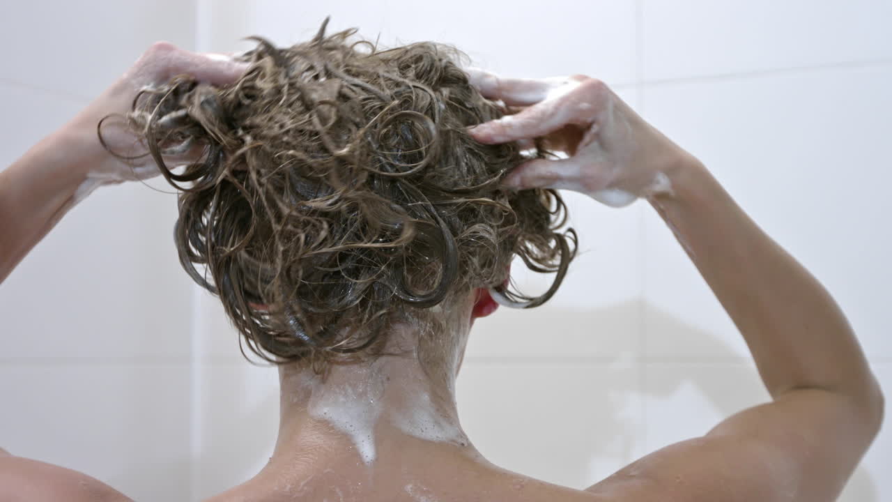 Donna che idrata i capelli con balsamo o shampoo
