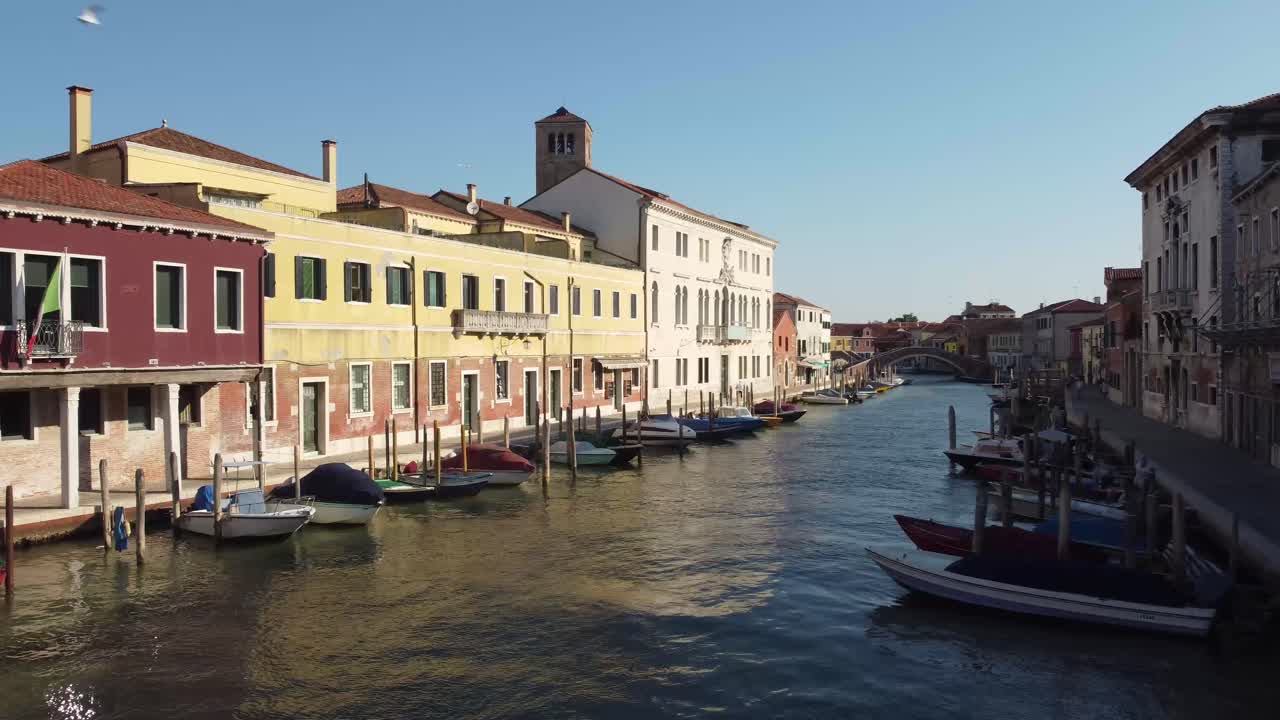 edificios icónicos de venecia con barcos amarrados y góndolas