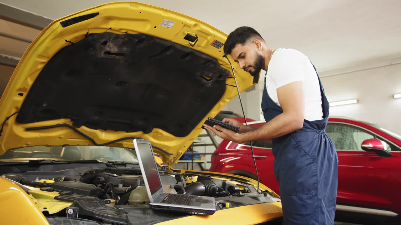 mecánico diagnosticando un coche amarillo en un garaje