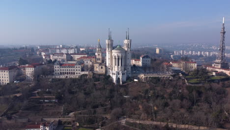 Vista-Aérea-De-Retroceso-De-La-Icónica-Basílica-De-Notre-dame-De-Fourvière,-Lyon,-Francia