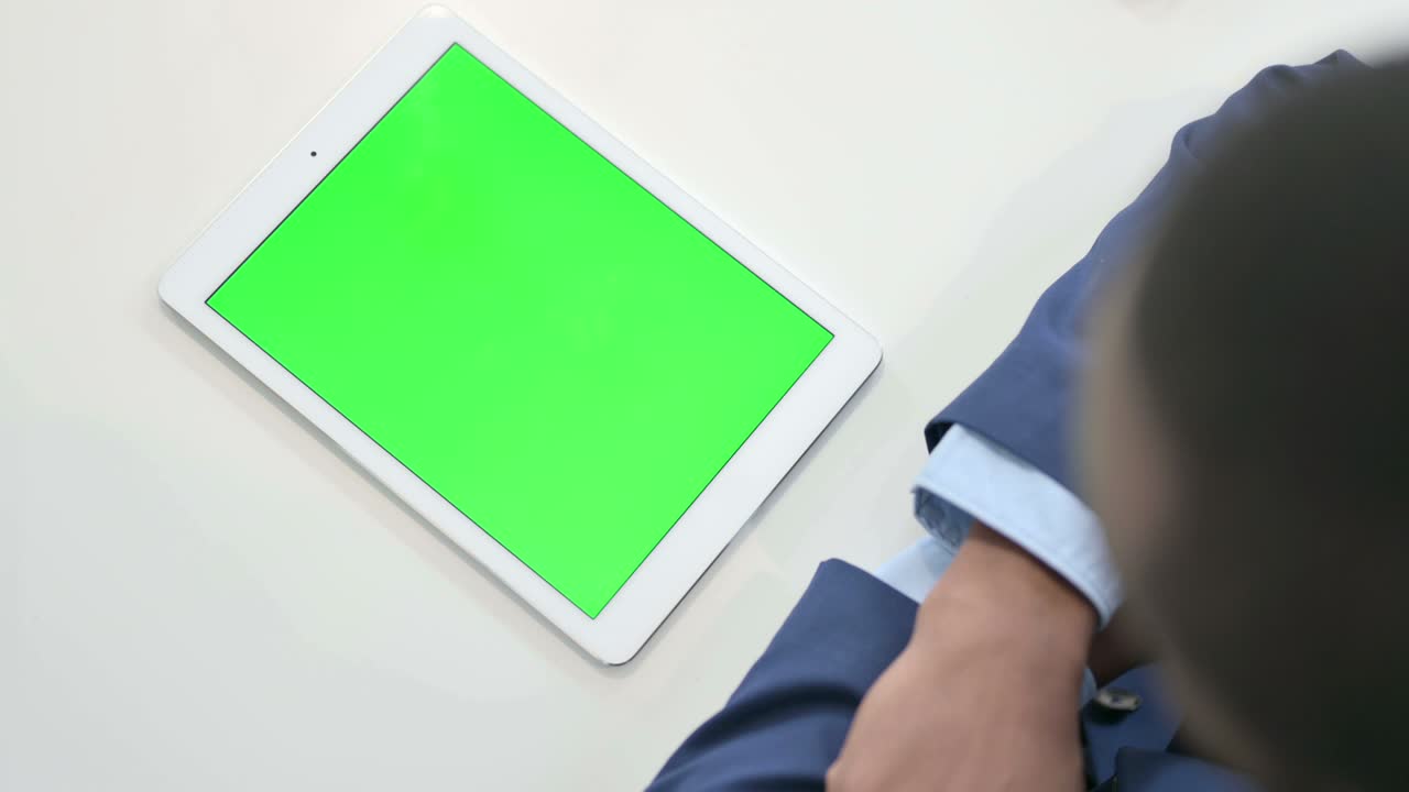 hombre de negocios mirando una tableta con pantalla de tecla de croma verde