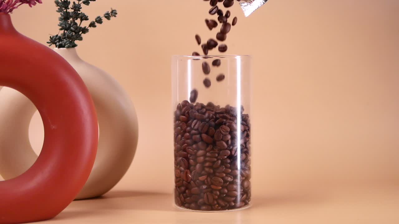Roasted Coffee Beans Pouring into a Glass Container