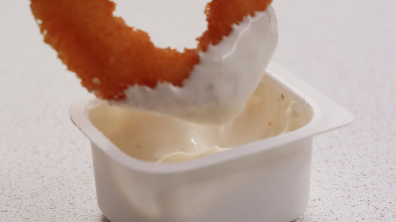 sumergir los anillos de cebolla en la salsa