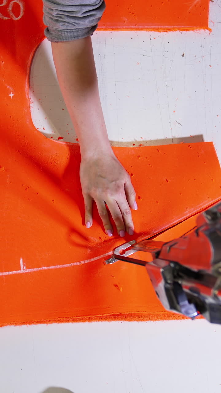 Close up of sewing process. Dressmaker woman making clothes on sewing machine in factory. Vertical video