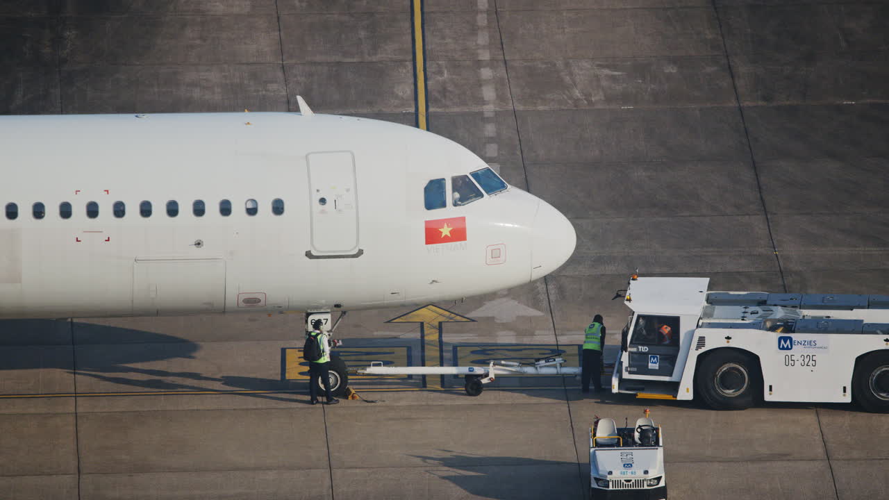 Il personale di terra prepara l'aereo commerciale per il pushback sul piazzale dell'aeroporto.