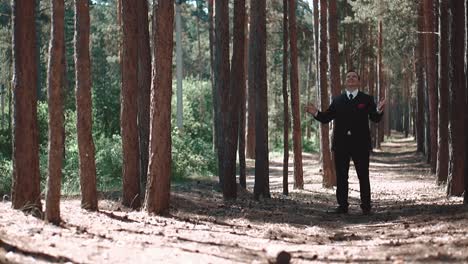 groom experiences a sense of joy and a fulfilled mission after the marriage standing in the forest he smiles