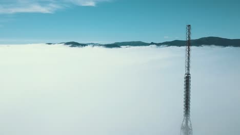 Alejando-La-Vista-De-Drones-De-La-Torre-De-Comunicaciones-Sugarloaf-En-Christchurch-Port-Hills-Nueva-Zelanda-Cubierta-Por-Una-Espesa-Capa-De-Nubes---Dolly-Shot