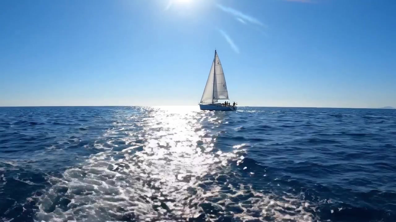 A tranquil sailing adventure on a bright sunny day, with a sailboat gliding gracefully over sparkling blue waters, leaving a gentle wake behind in the shimmering ocean.