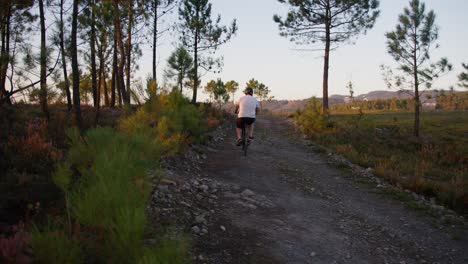 un ciclista viaja a lo largo de un camino de tierra al atardecer, usando un casco y empujando a través de un sendero desafiante. capturado en 50 fps con un blackmagic 6k pro para una sensación dinámica y arenosa.
