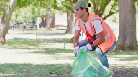 happy young man cleaning a park in an eco friendly