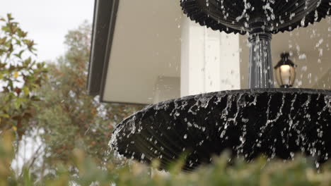 House-Water-Fountain-Feature-Spraying-Water-In-Wind,-SLOW-MOTION-CLOSE-UP