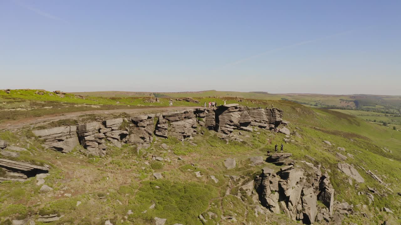 여름에 영국 시골에서 언덕을 오르는 사람들의 공중 와이드 샷