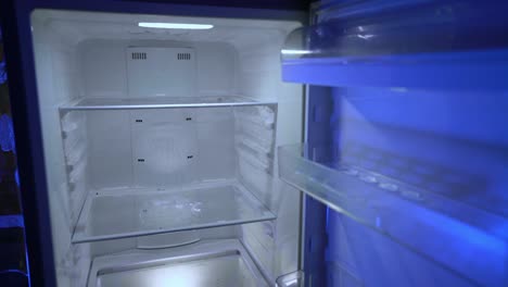 opening and closing the door of an empty fridge. nothing to eat or strict dieting.