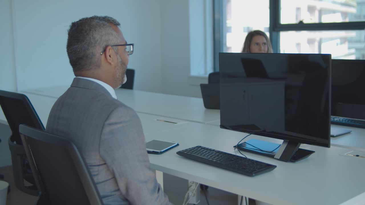 colegas sentados en la mesa de reuniones con computadoras
